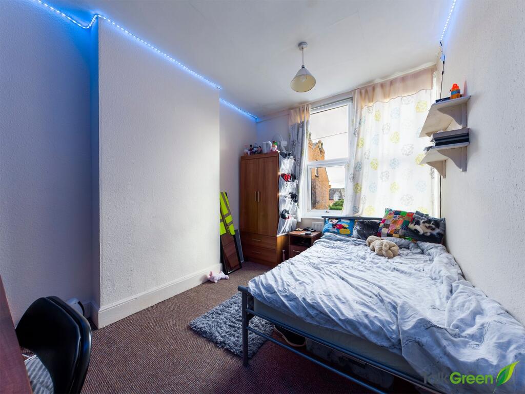 A cozy single bedroom featuring a bed with play...