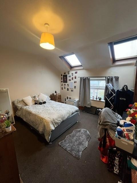 A spacious and cozy master bedroom with a comfo...