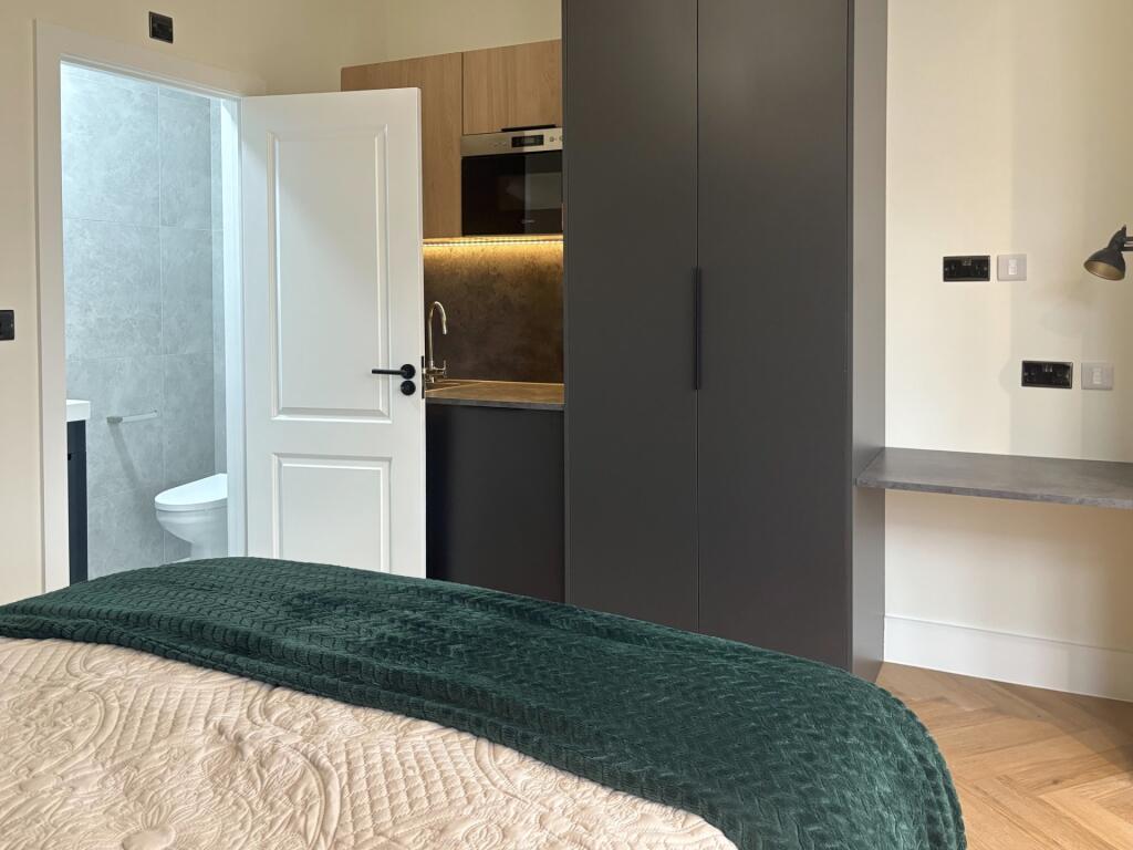 Stylish bedroom with a cozy double bed, built-i...