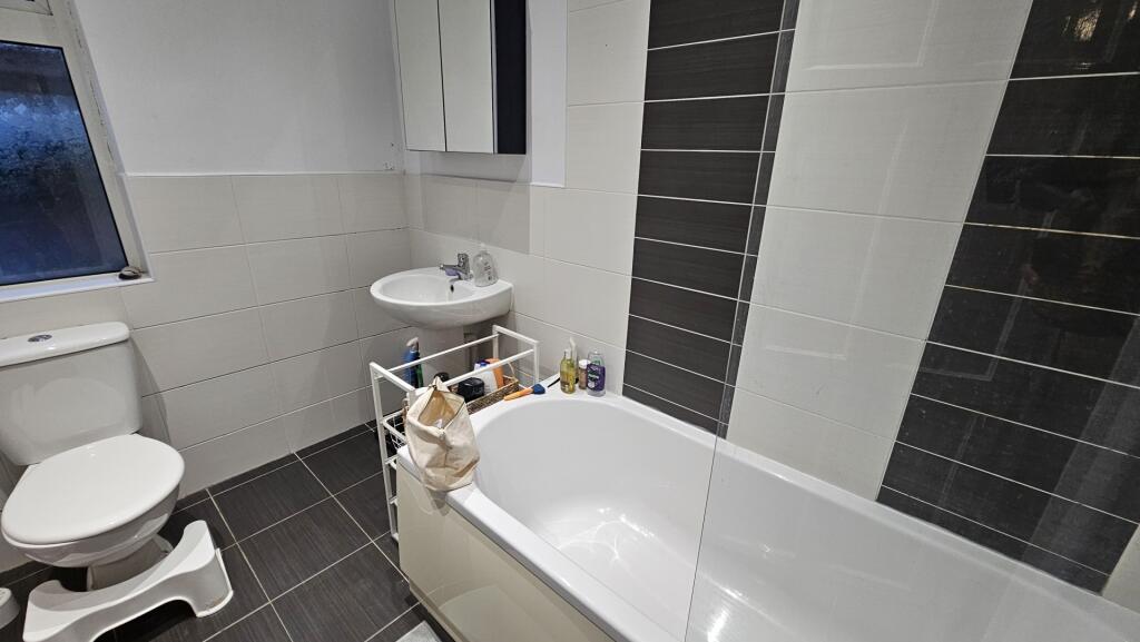 A modern bathroom suite featuring a clean white...