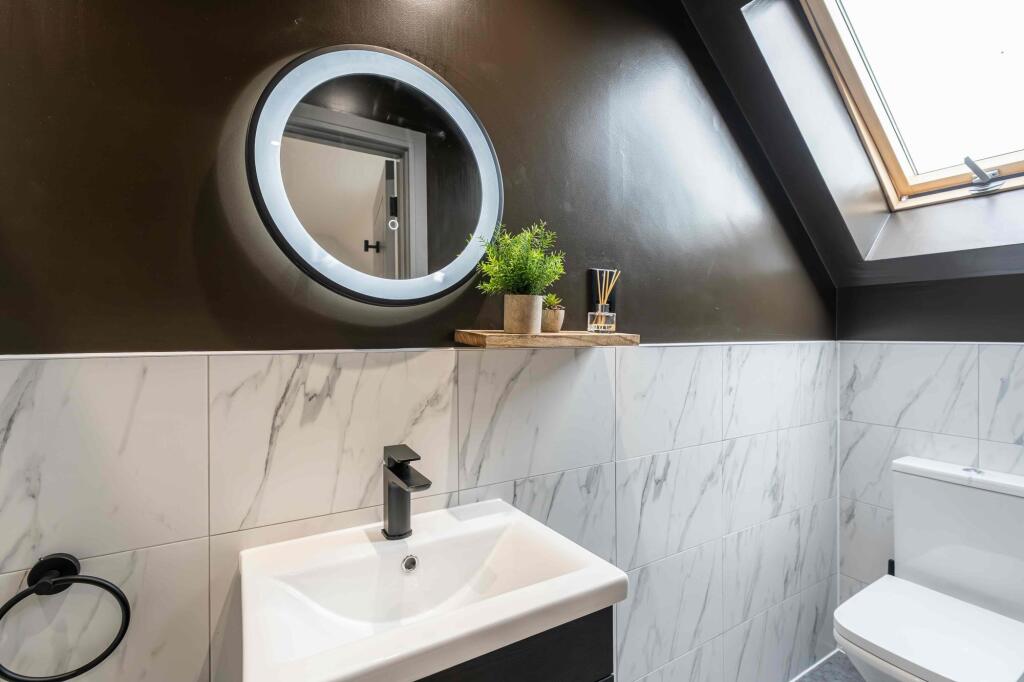 Modern bathroom featuring a sleek white sink, a...
