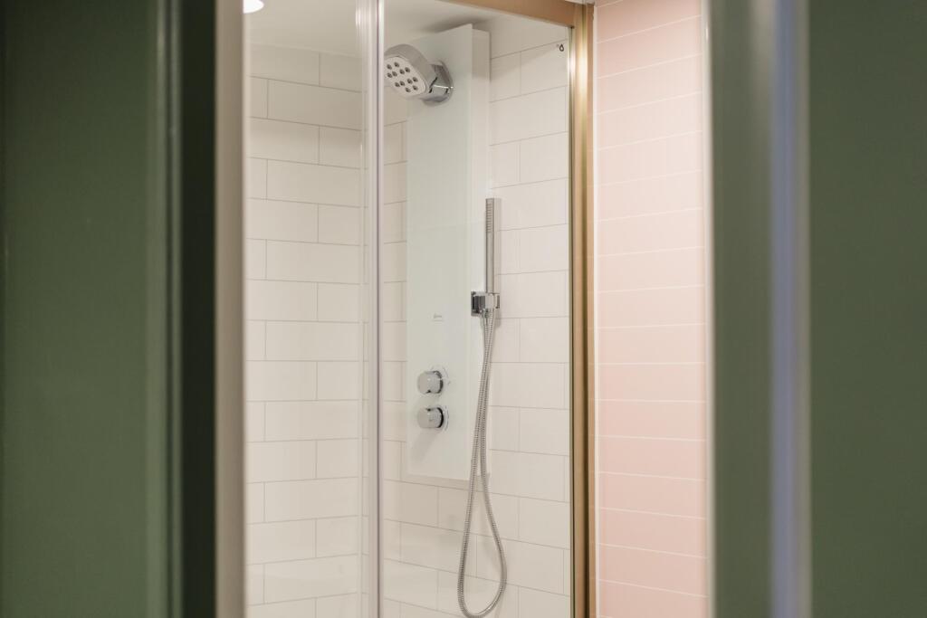 Clean and functional bathroom with a shower, fe...