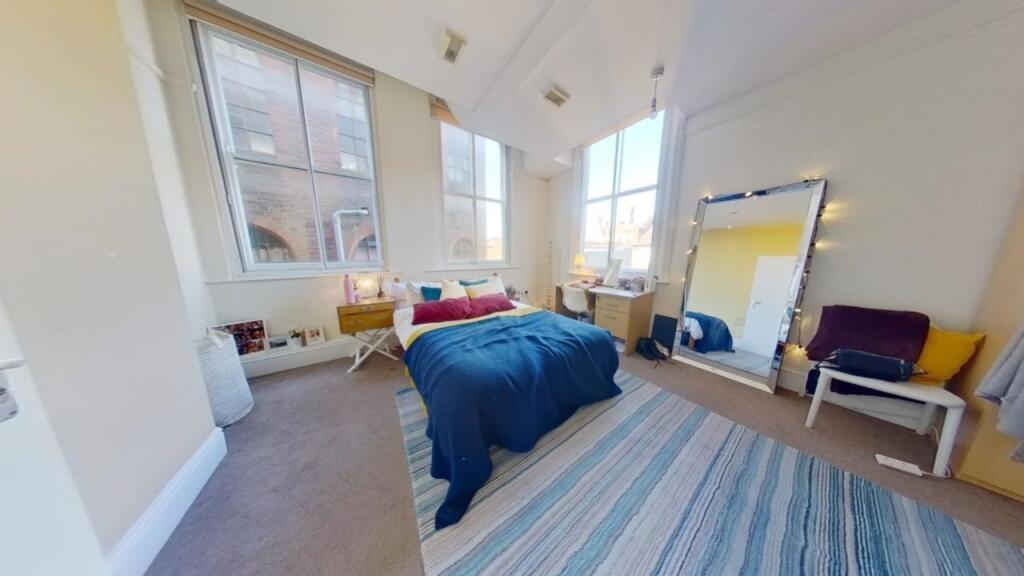 Bright and spacious master bedroom featuring la...