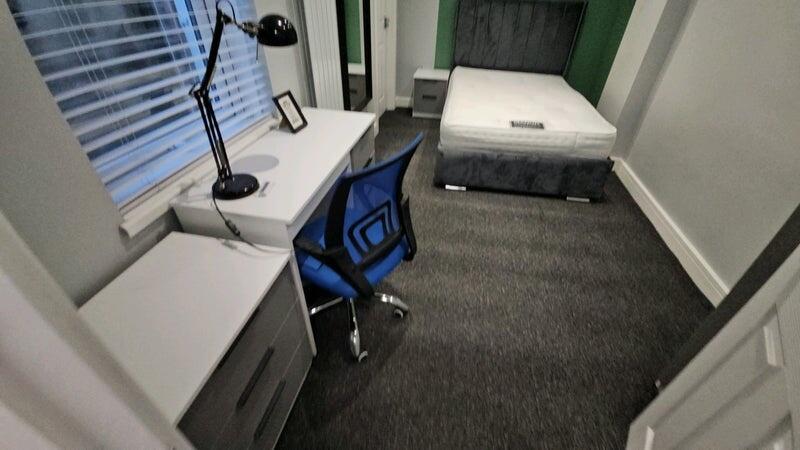 A tidy single bedroom featuring a comfortable b...