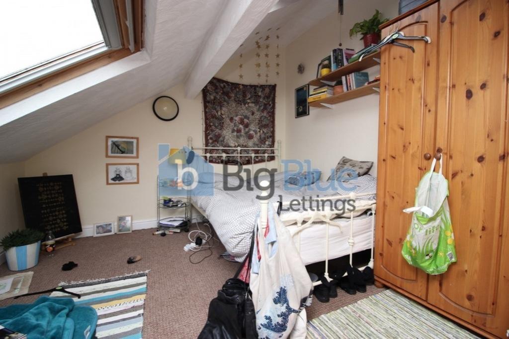 Cozy single bedroom featuring a sloped ceiling ...