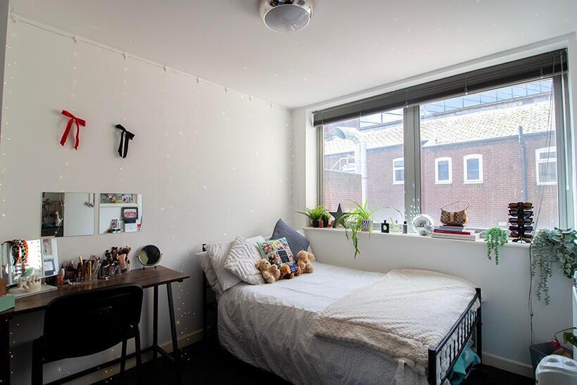 A cozy double bedroom featuring large windows t...
