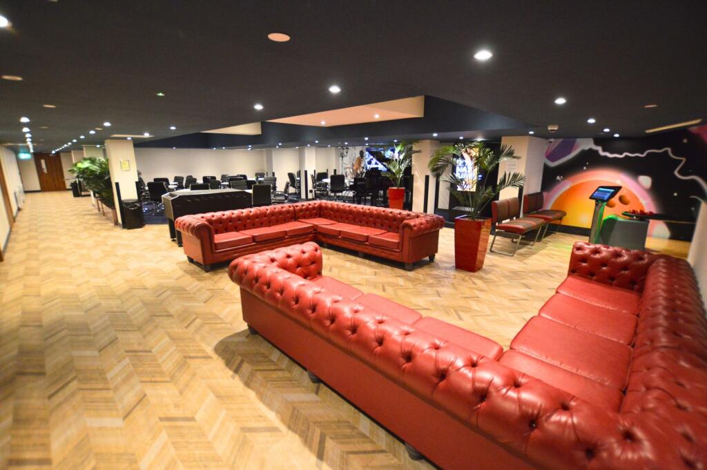 Spacious communal lounge featuring large red le...