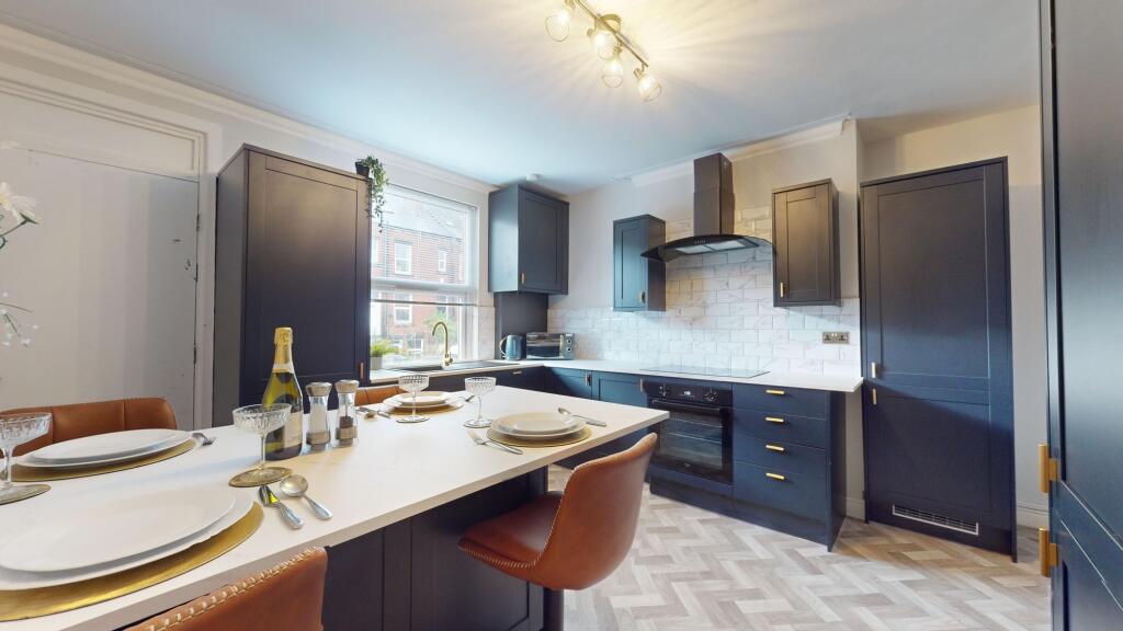 This modern kitchen boasts sleek cabinetry and ...