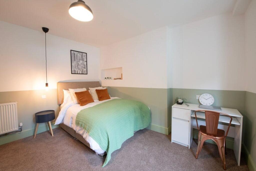 This inviting double bedroom features a comfort...
