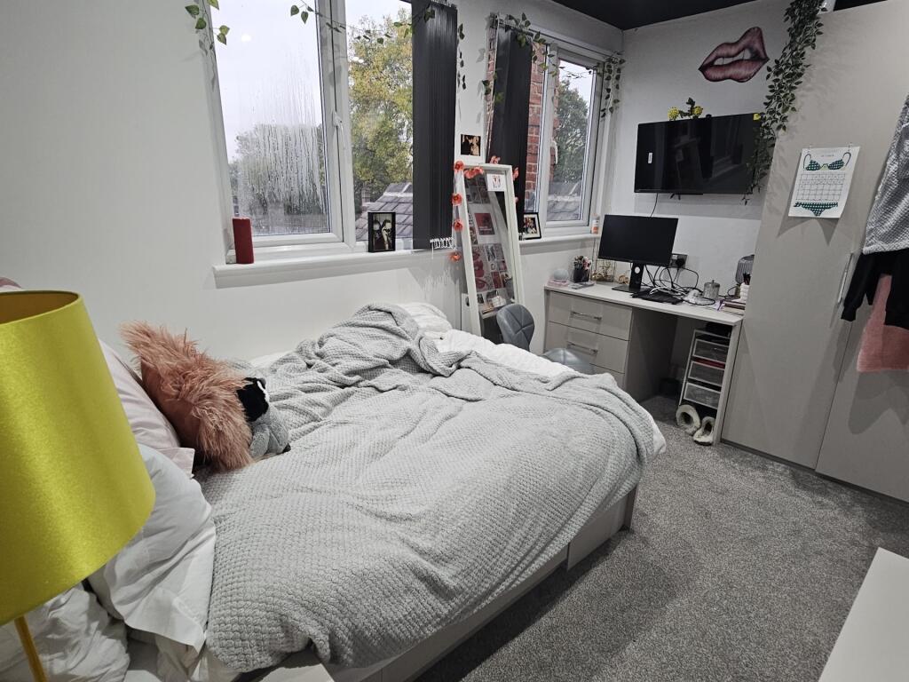 A bright and tidy bedroom featuring a comfortab...