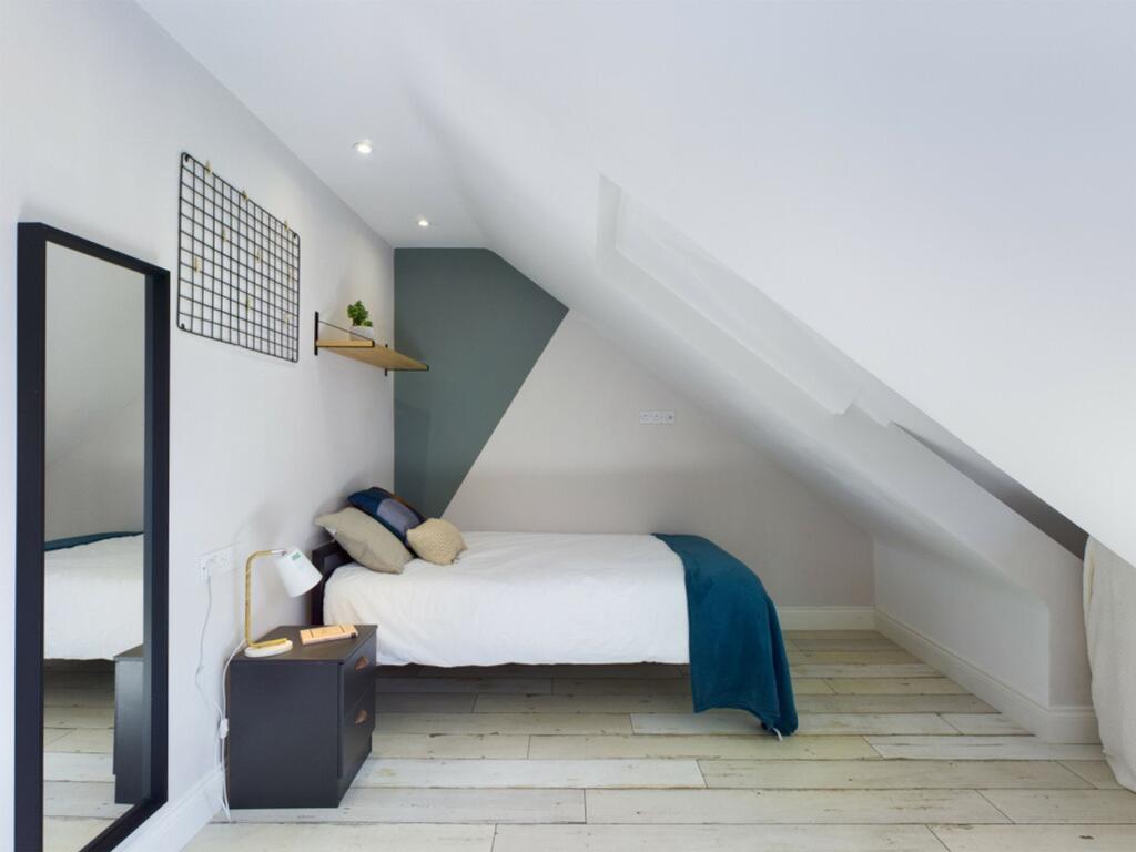 A bright and inviting double bedroom with styli...