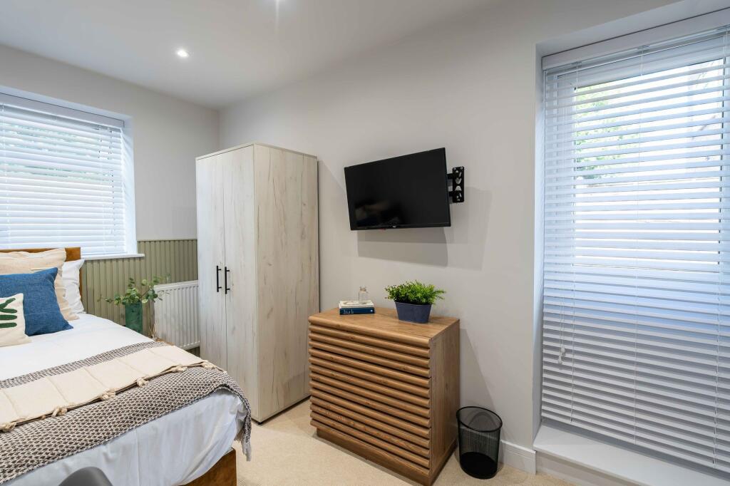 A bright and inviting bedroom featuring a well-...