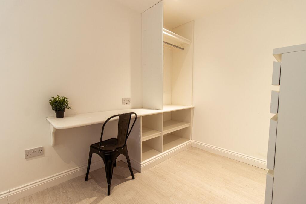 Bright, minimalist single bedroom with a built-...