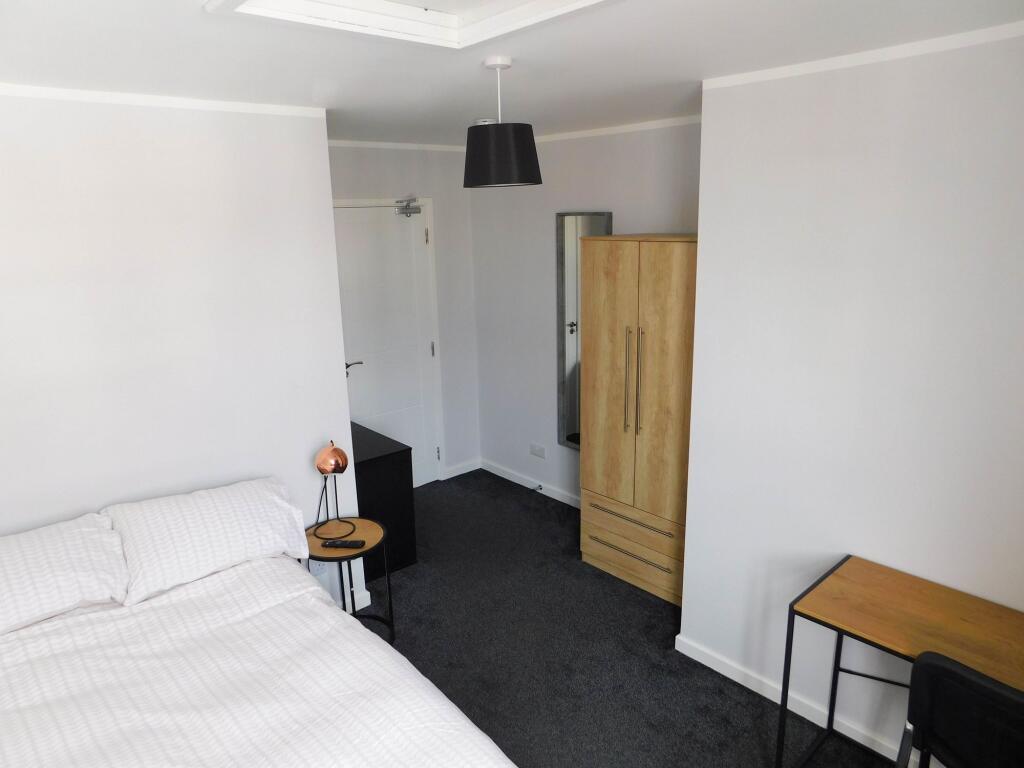 Bright and modern master bedroom featuring a co...