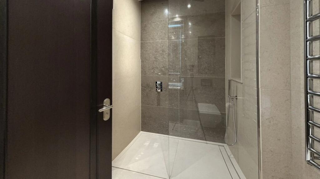 A sleek, modern bathroom suite featuring a spac...