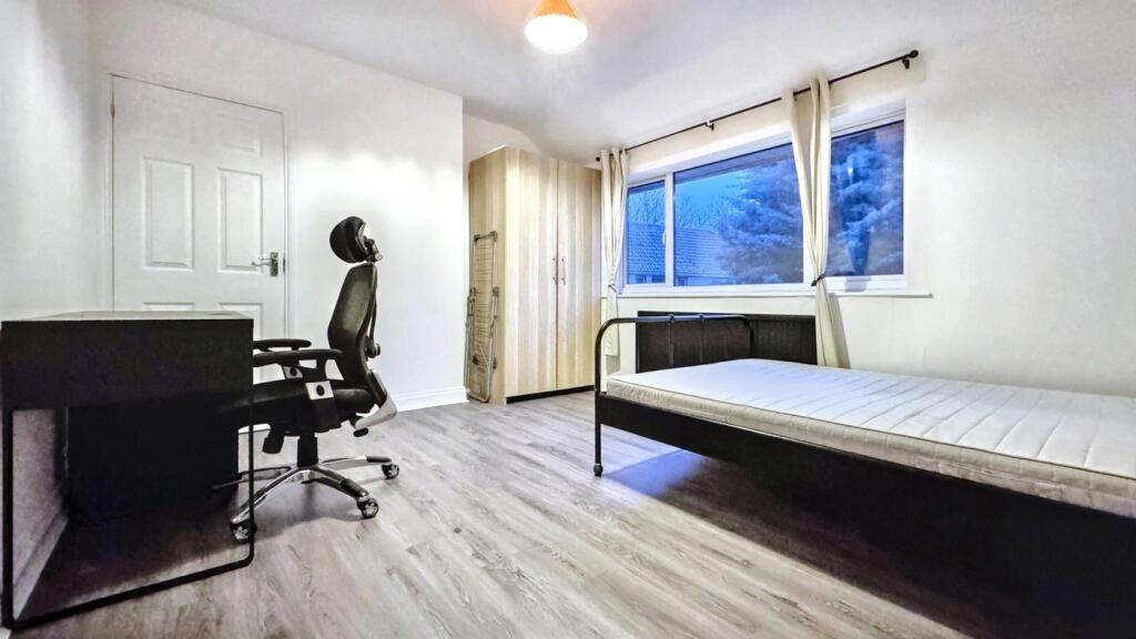A spacious and well-lit double bedroom, perfect...