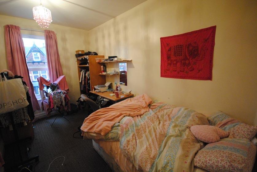 A cozy bedroom featuring a single bed with colo...