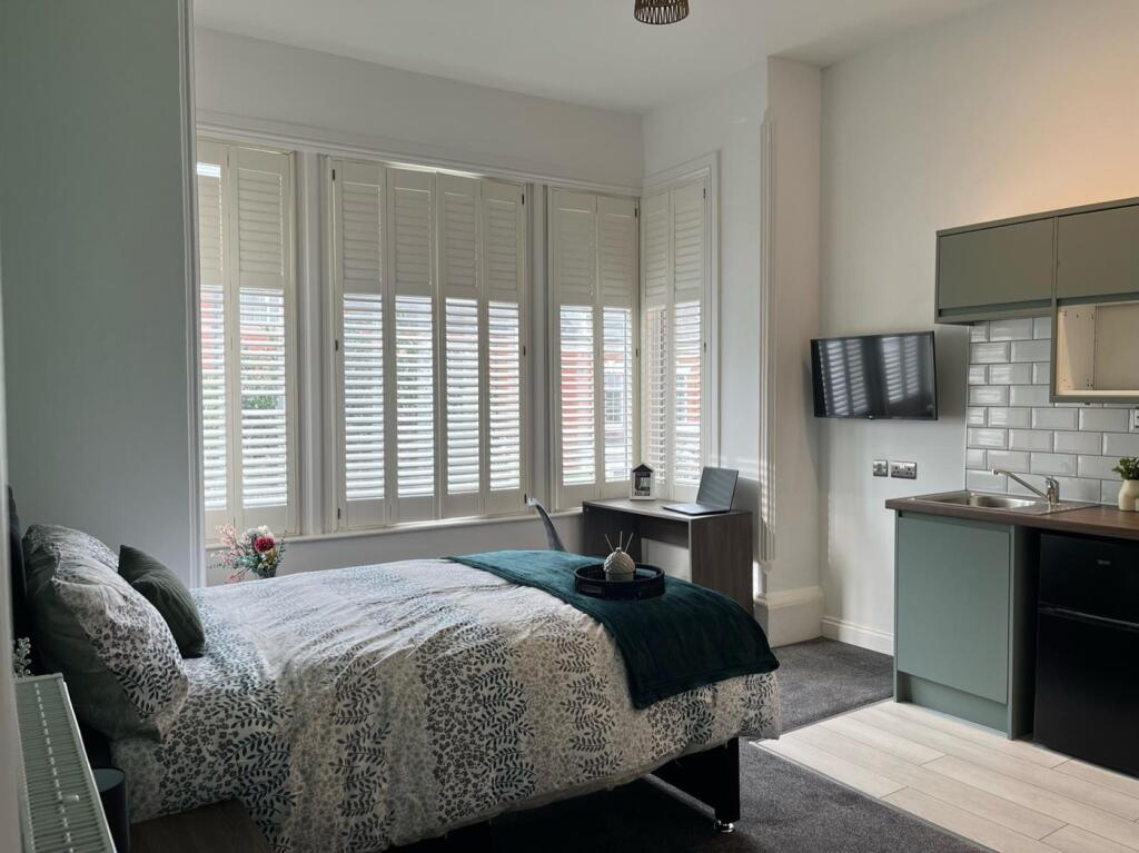 This stylish double bedroom features large wind...