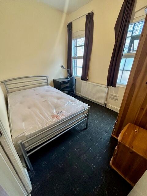 Cozy double bedroom featuring a metal frame bed...