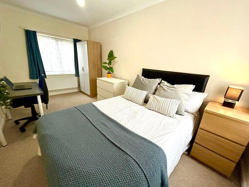 This inviting double bedroom features a cozy be...