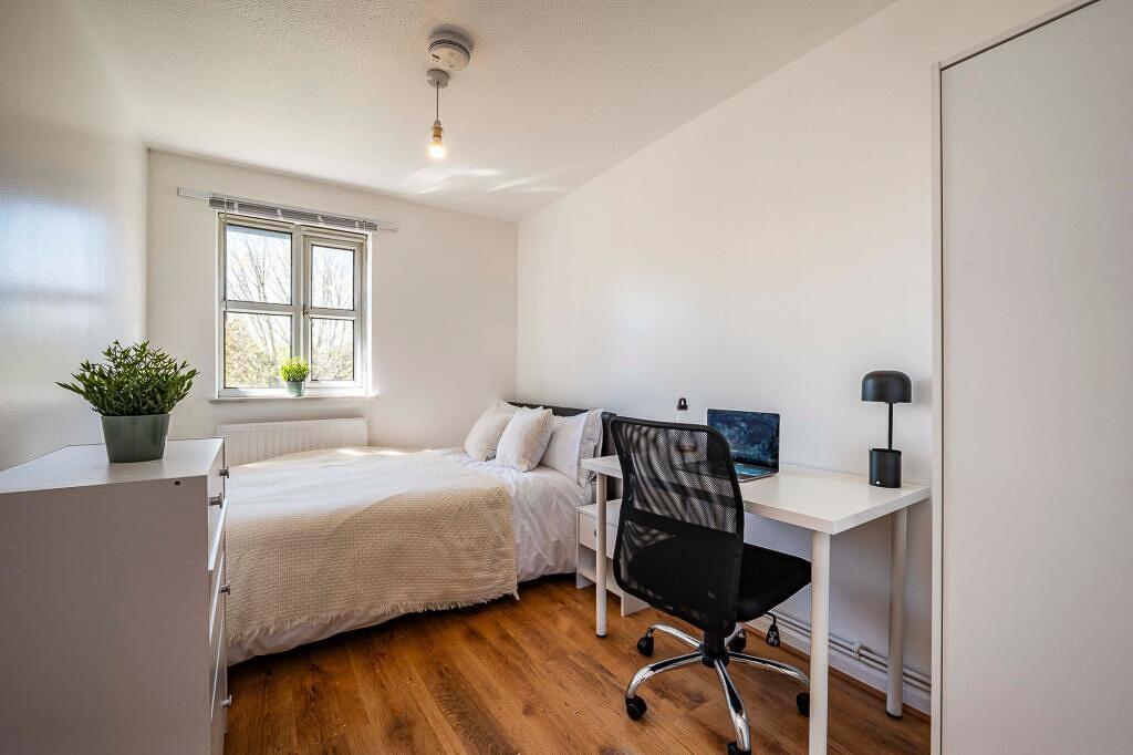 A bright and tidy bedroom featuring a comfortab...