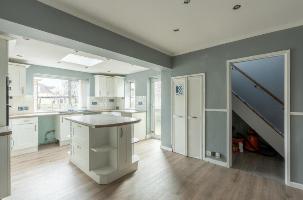 A spacious and well-lit kitchen designed for bo...