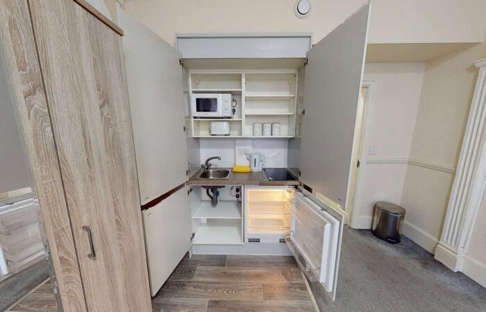 Compact and tidy kitchenette with essential app...