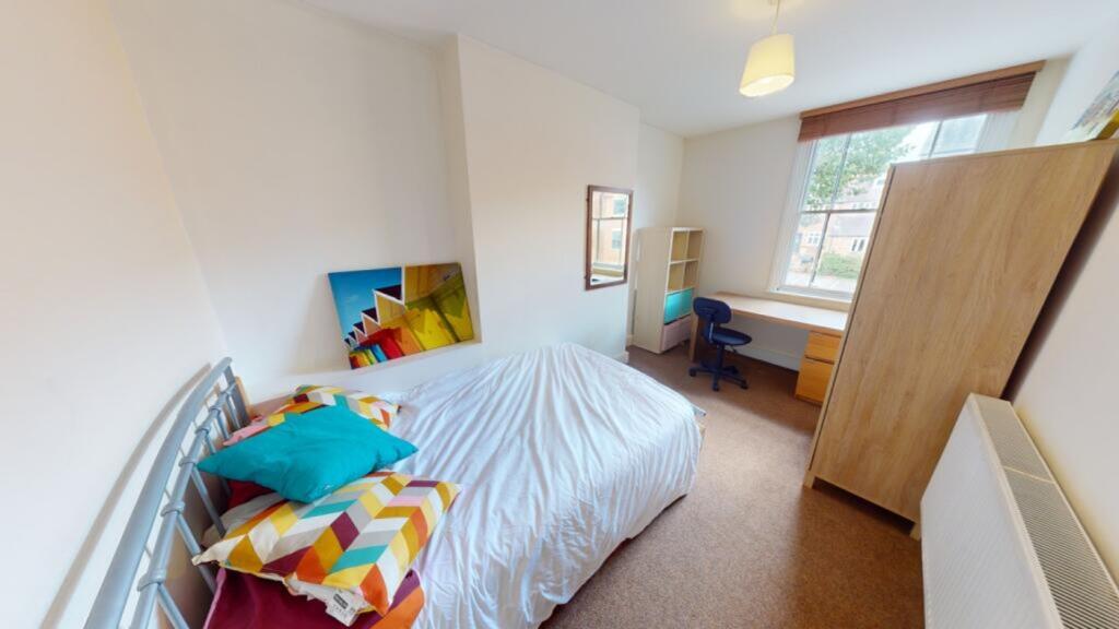 A bright and inviting double bedroom with cozy ...