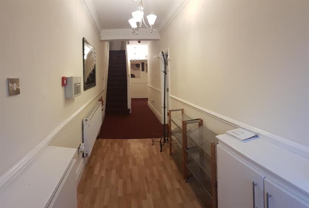 Well-maintained entrance hallway with wall pane...