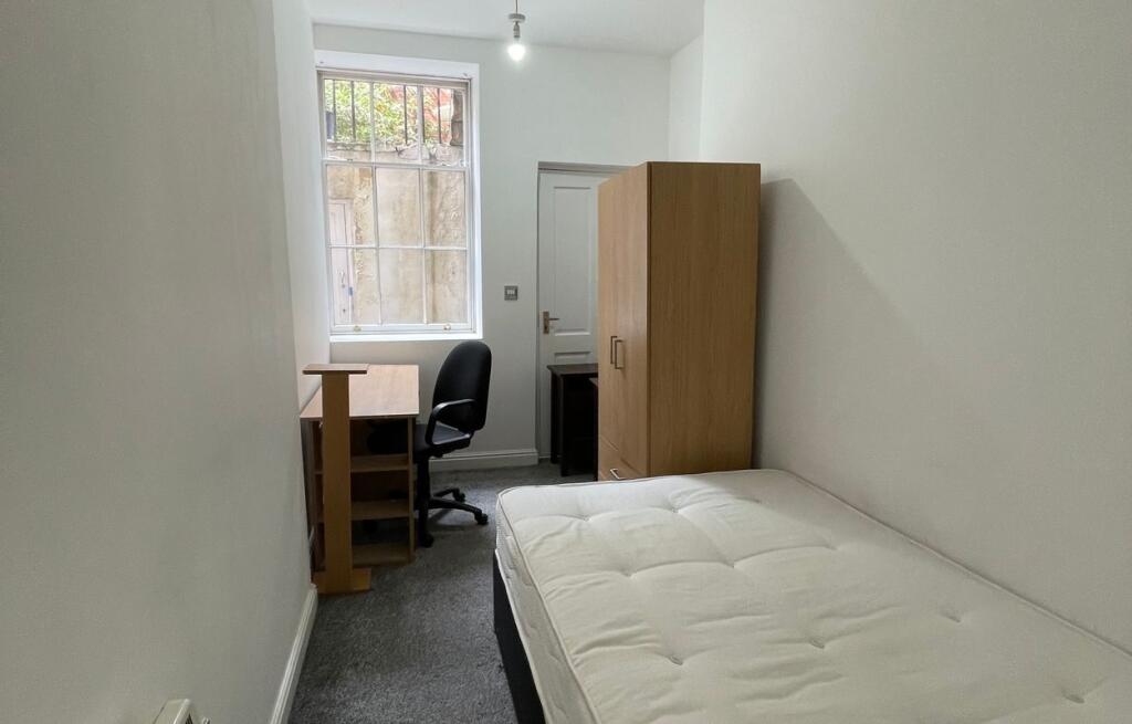 A compact and tidy single bedroom featuring a c...