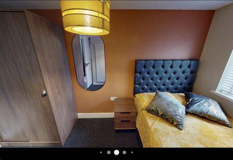 Well-presented bedroom with a tufted upholstere...