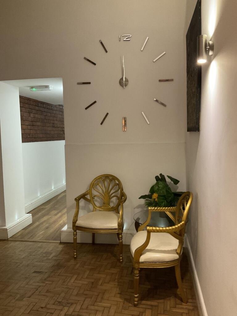 A cozy hallway featuring two elegant gold chair...