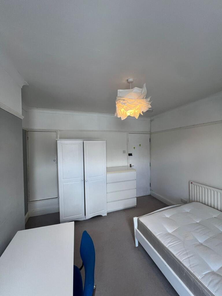 A clean and modestly furnished bedroom featurin...