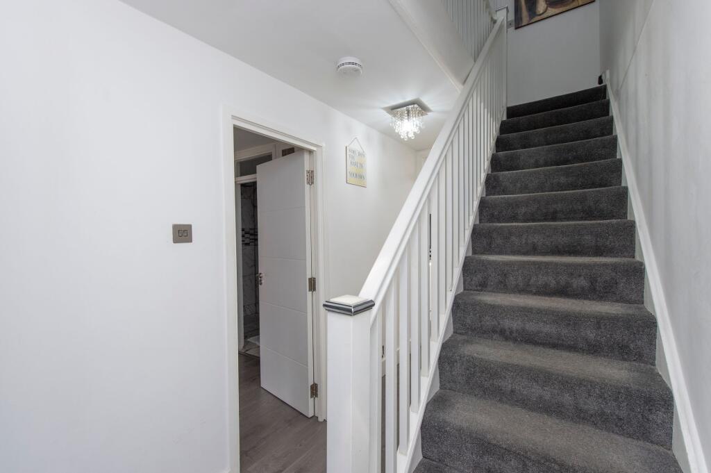 Bright and clean hallway featuring a modern sta...