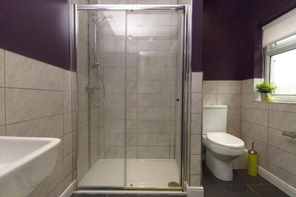 A modern and tidy bathroom featuring a spacious...