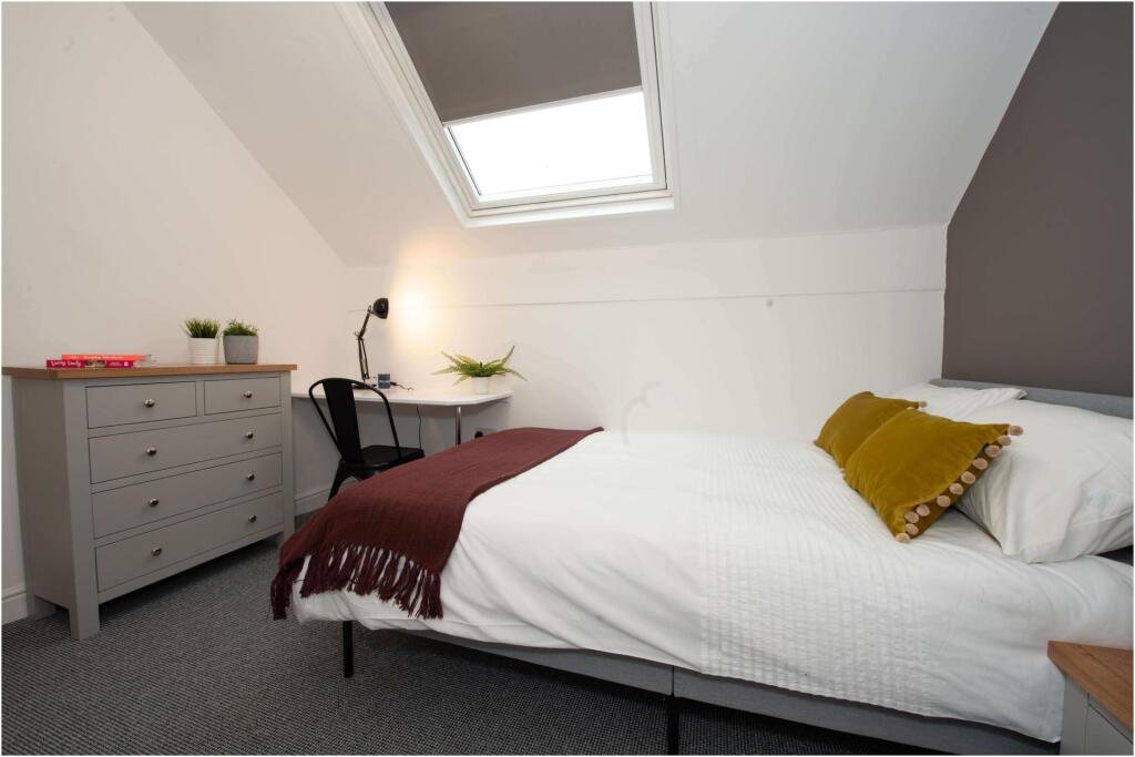 A bright and inviting master bedroom featuring ...