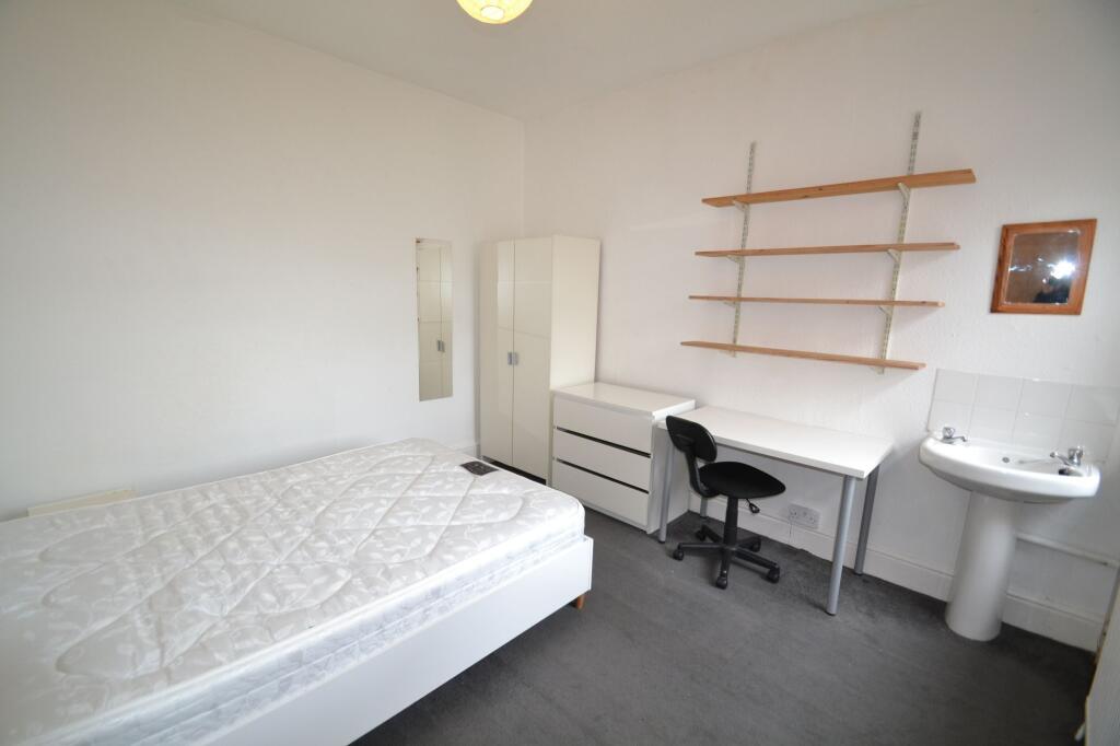 A neat and functional single bedroom featuring ...