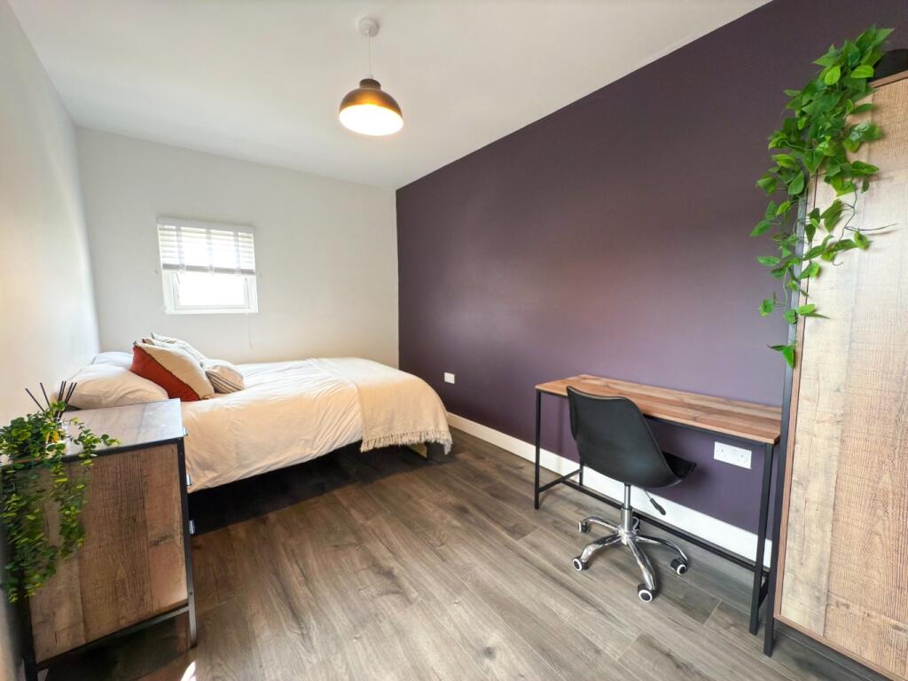 A modern, well-lit bedroom featuring a double b...