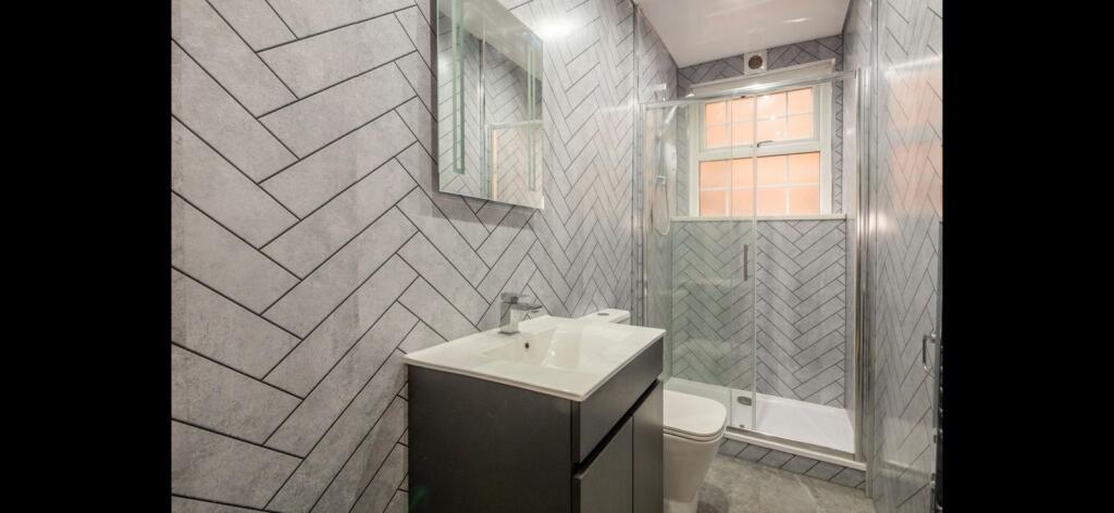Contemporary bathroom with a sleek vanity unit,...