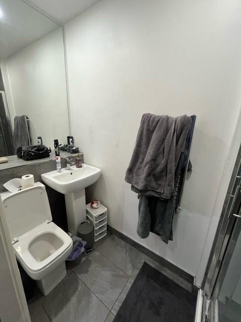 Compact bathroom with tiled floor, pedestal sin...
