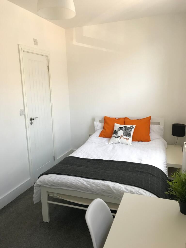 This cozy double bedroom features a comfortable...