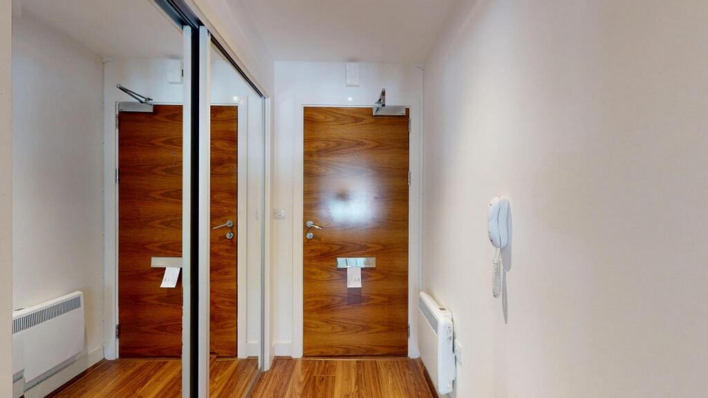 A clean and modern hallway featuring wood lamin...