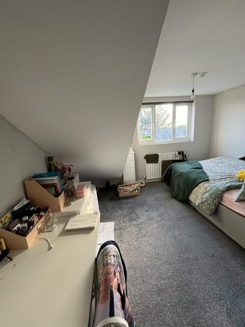 Bright, cozy bedroom with sloped ceiling, large...