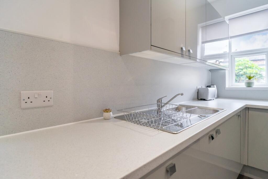 This modern kitchen features sleek cabinetry an...
