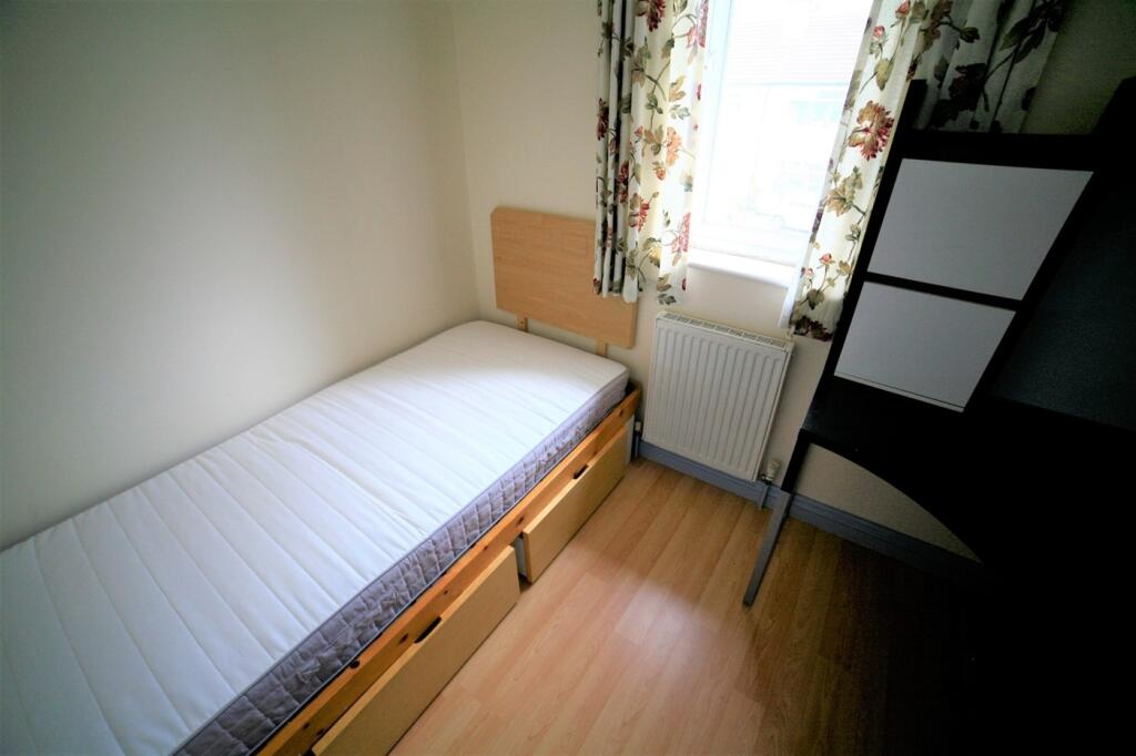 This cozy single bedroom features a comfortable...