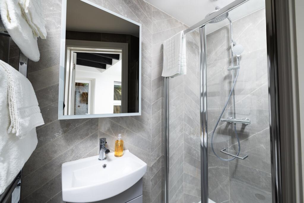 A stylish and modern bathroom featuring a sleek...