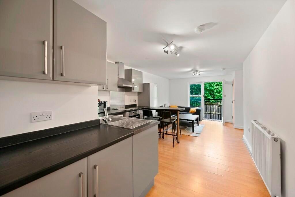 Bright, modern kitchen and dining area with cle...