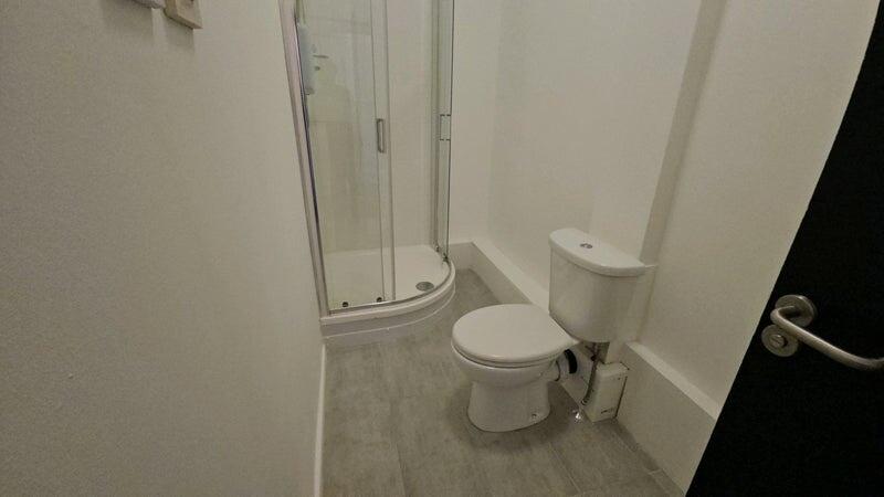 A clean and modern bathroom featuring a compact...
