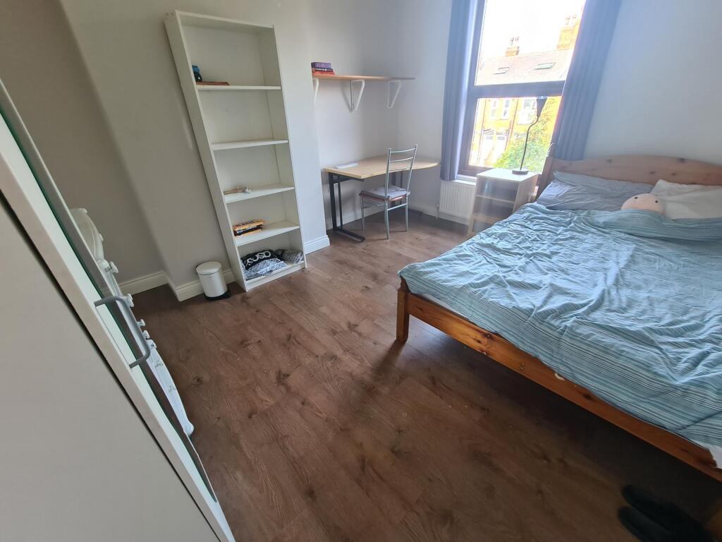 Bright double bedroom featuring a comfortable w...
