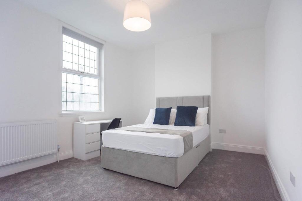 Bright and fresh master bedroom featuring a com...
